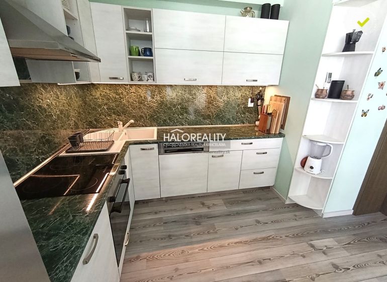 A kitchen in a 3-room apartment with a wooden decor floor and a green granite countertop.