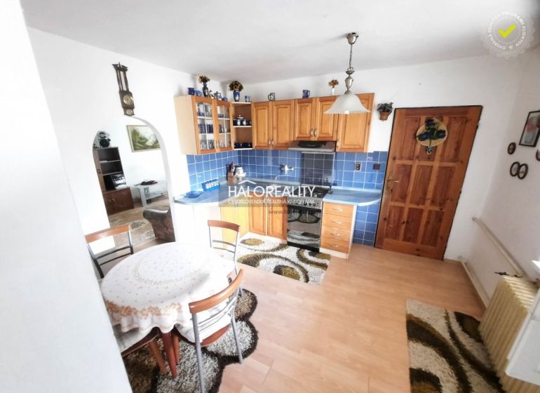 A kitchen in a family house with blue tiles and a floor with a wood decor.