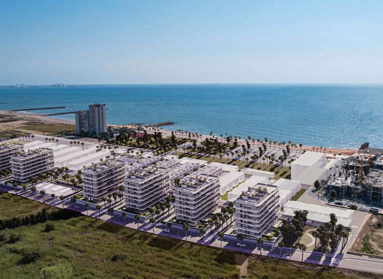 The coast with new apartment buildings and palm trees in the town of El Puig, overlooking the sea.