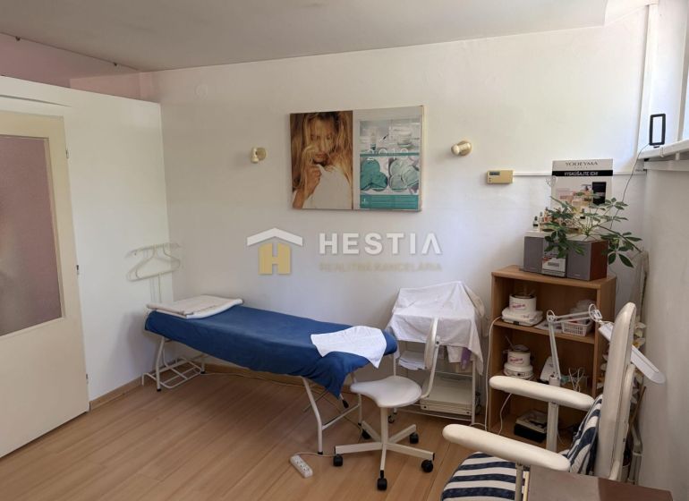 A cosmetic room with a bed, chairs, and decorations, floor with wooden decor.