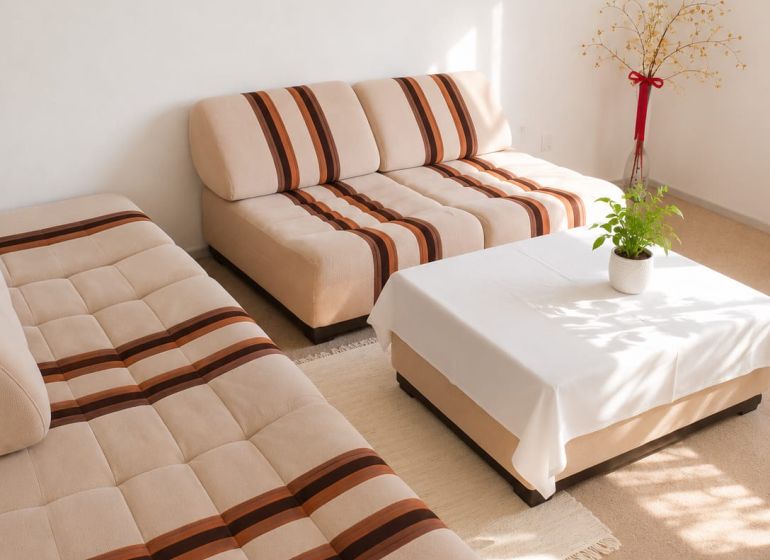 Living room in a 3-room apartment with light sofas and a decorative plant.