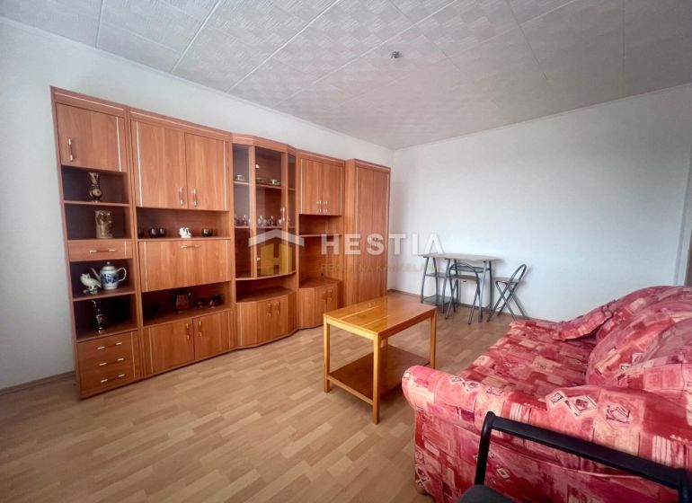 Living room in a 3-room apartment with a wooden decor floor and wooden furniture.