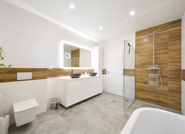 A bathroom in a family house with brown wooden decorations and two sinks.