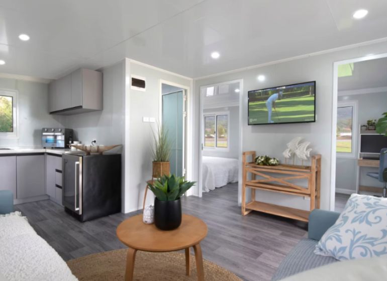Interior of a family house with a wooden decor floor, kitchen, and living room.