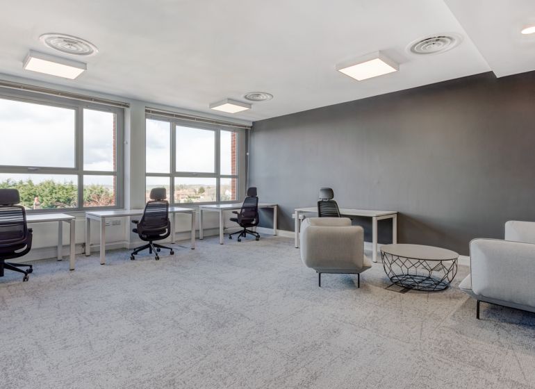Offices with large windows, gray walls, and modern furniture.