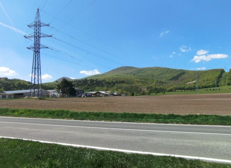 Landscape on Továrenská in Smolenice with agricultural and forest lands and power lines.
