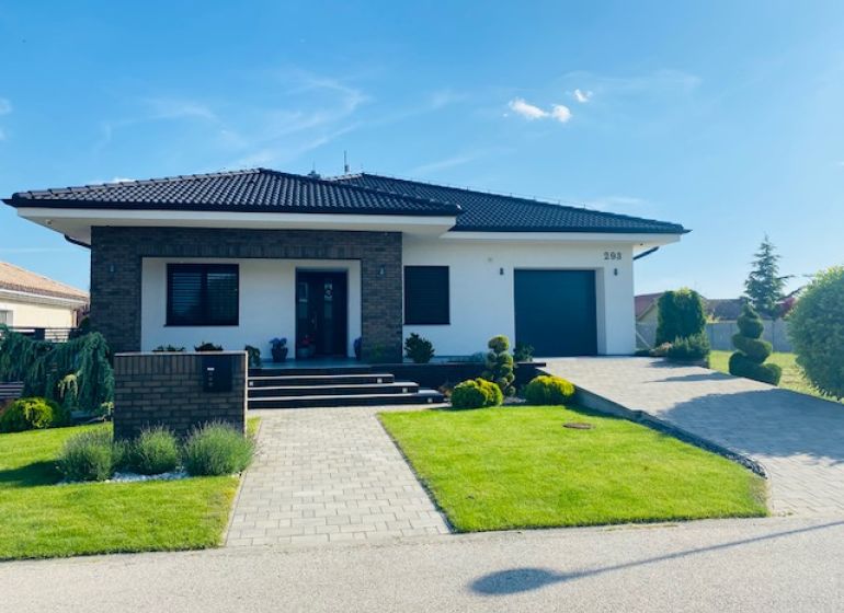 A family house on Jasná Street in Veľké Dvorníky, with a well-maintained garden and a garage.