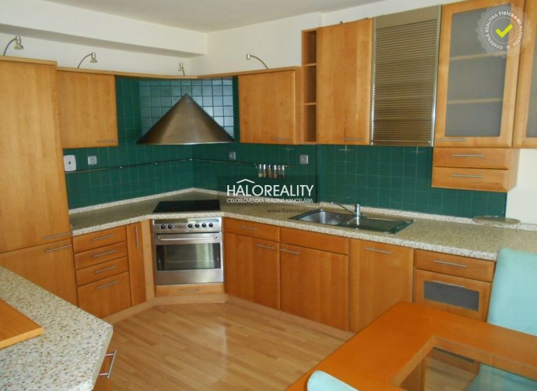 A kitchen in a 3-room apartment with a wooden decor floor and green tiles.