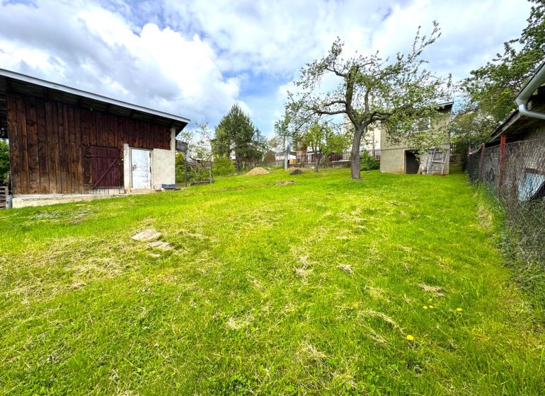 A garden plot for living in Lipany with a wooden shed and a grassy area.