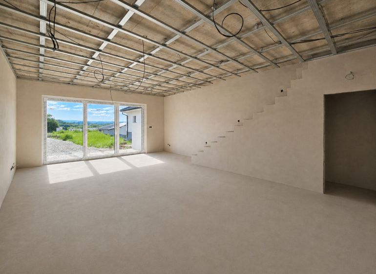A spacious room in a 5 or more bedroom apartment with a staircase and large windows.