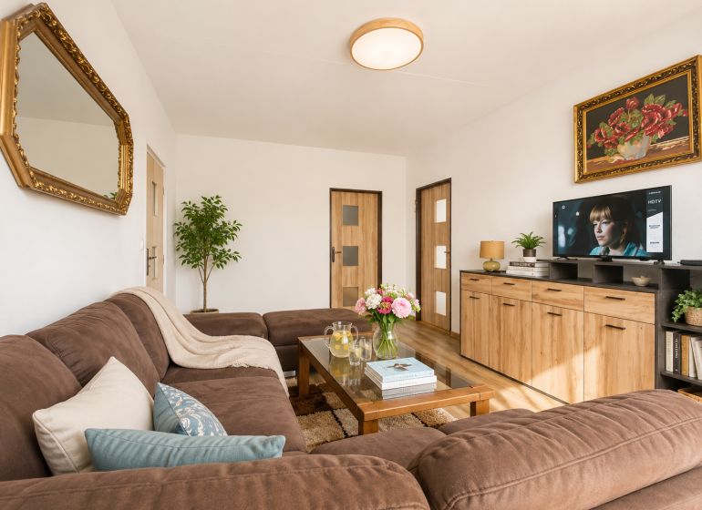 Living room in a 3-room apartment, with a comfortable sofa and a decorative mirror on the wall.