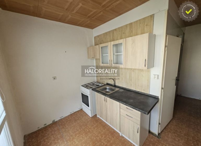 Kitchen corner with a gas stove in a studio apartment and a floor with a wooden decor.