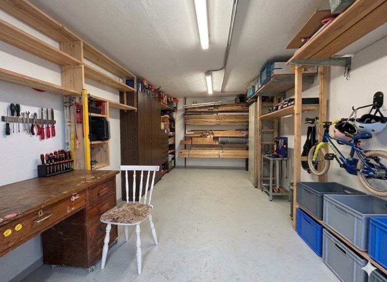Workshop with a table, shelves, and a bicycle in a 3-room apartment.