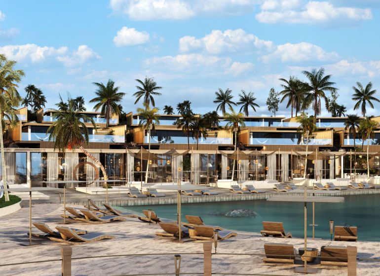 Palm trees and loungers by the beach in Nungwi, in front of the resort with palm trees.