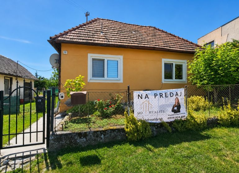 A family house for sale in Demandice surrounded by a garden and fencing.