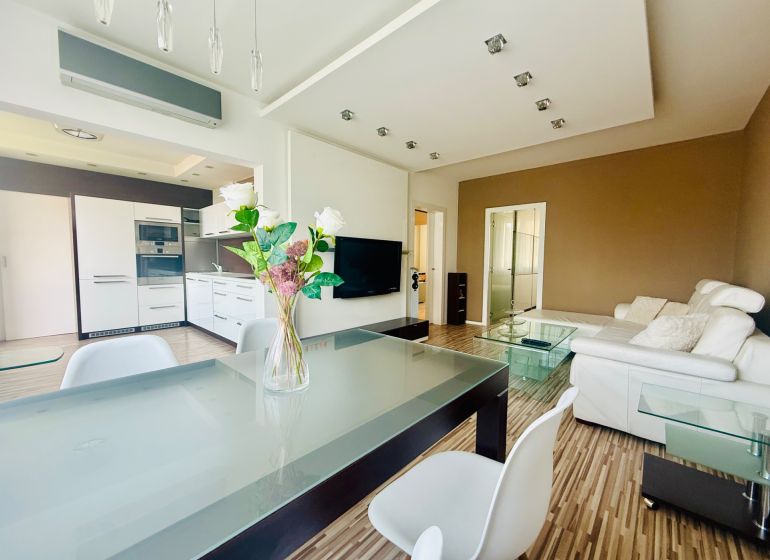 Living room with kitchen in a three-room apartment with a wooden decor floor.