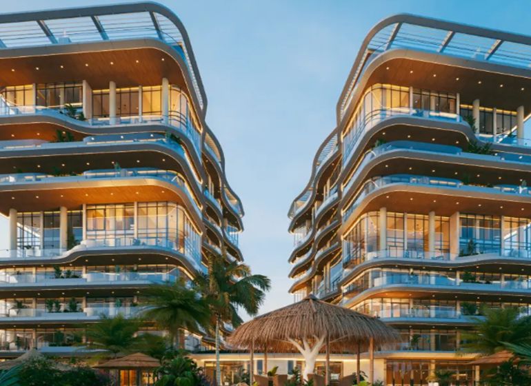 Design apartment buildings with glass facades in Paje surrounded by tropical vegetation.
