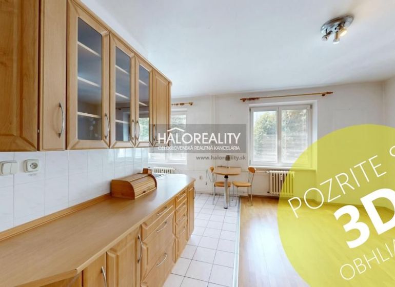 A kitchen in a 3-room apartment with wooden decor cabinets and a dining table.