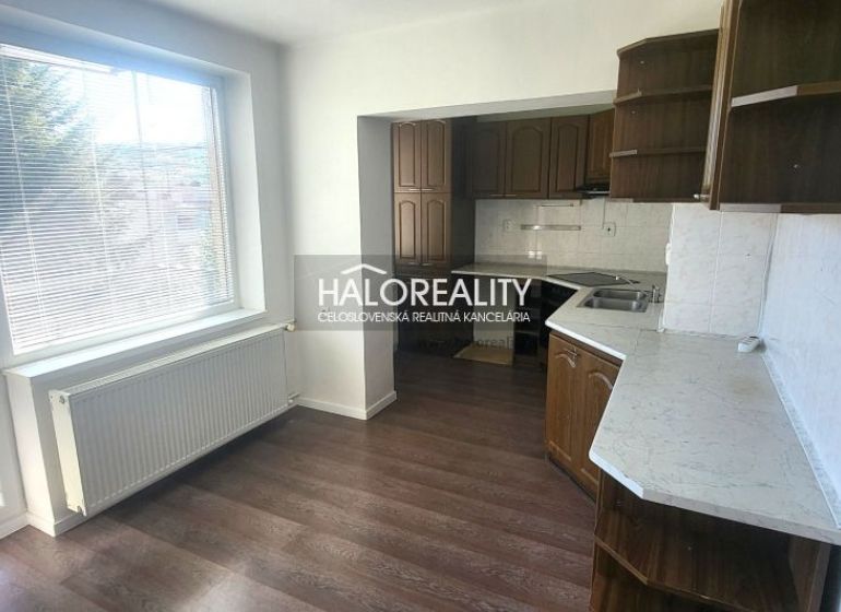 A kitchen in a 3-room apartment with a kitchen unit and a floor with a wooden decor.