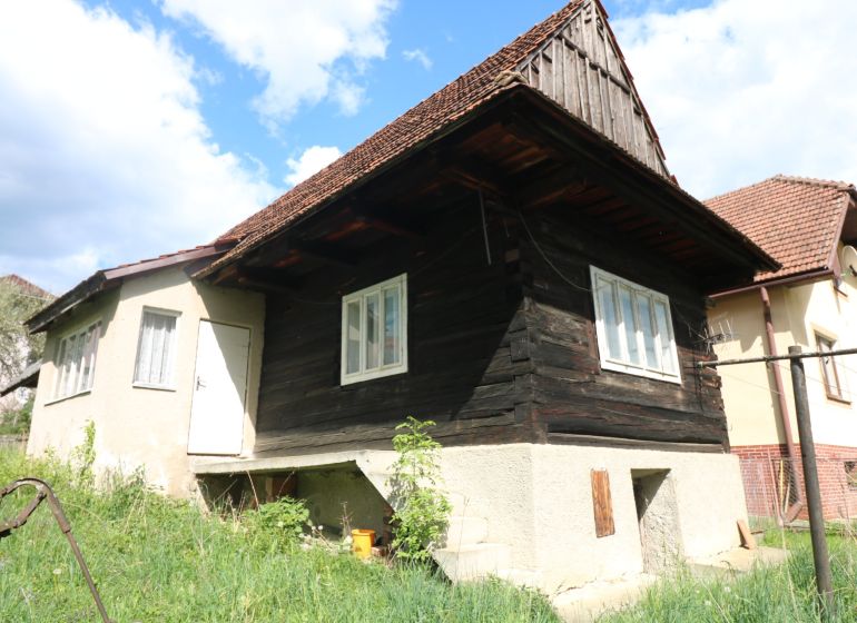 A log cabin with a concrete foundation on Matúšovská Street, Žaškov, surrounded by green grass. Construction of houses.