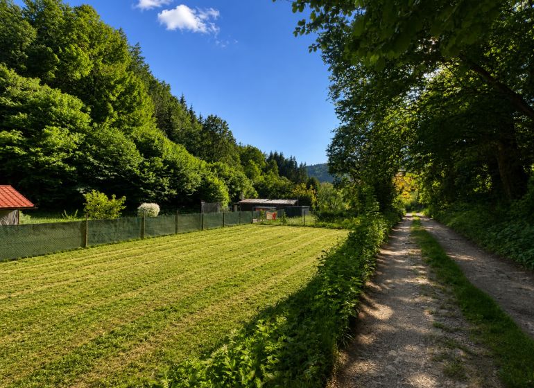A plot for residential use in Kostiviarska, Banská Bystrica, next to Kostiviarska Road, surrounded by greenery.