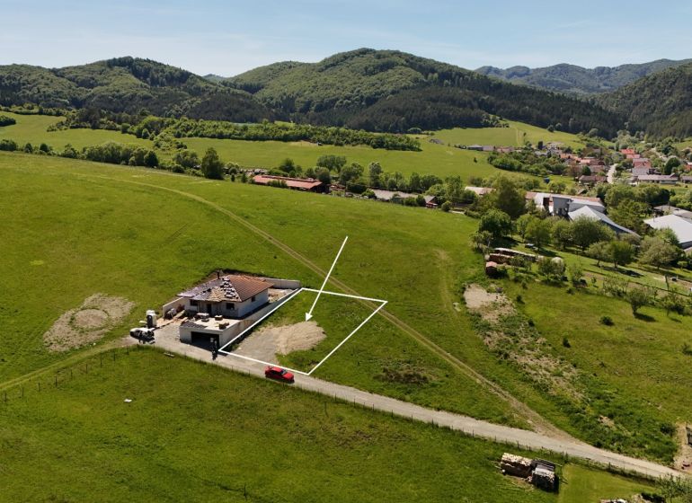 Residential plots in Lietavská Svinná-Babkov amidst green countryside with a village in the background.