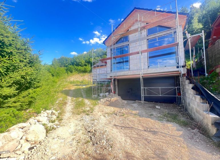 A family house under reconstruction with scaffolding, surrounded by nature in Badín, Banská Bystrica district, Slovakia.