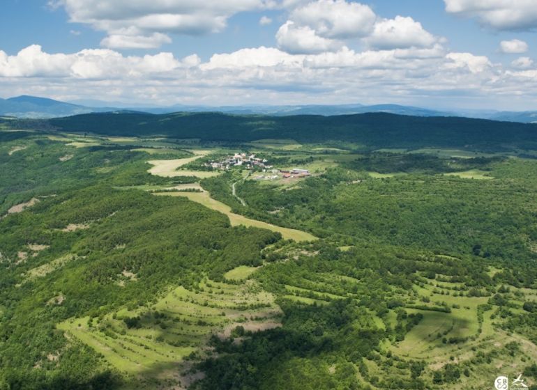 Aerial view of agricultural and forest lands in Ábelová surrounded by forests and meadows.