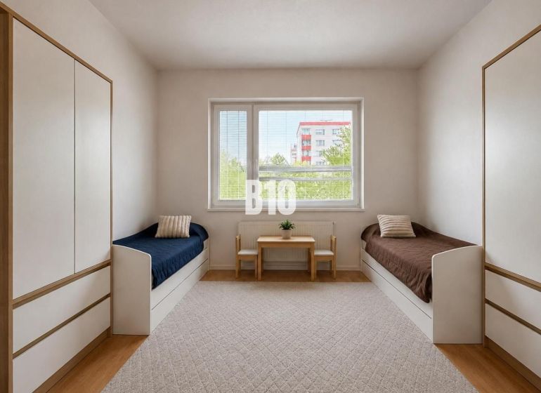 A children's room in a two-room apartment with two beds, a table, and storage space.