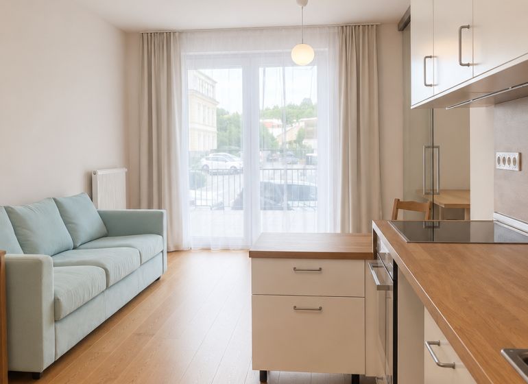 Living room in a two-room apartment with a wooden decor floor and a light-colored sofa.