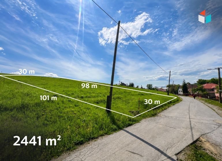 Lands - housing in Fintice with an area of 2441 m², next to the road under the blue sky.