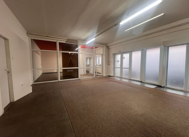 Commercial spaces with glass partitions and carpet flooring.