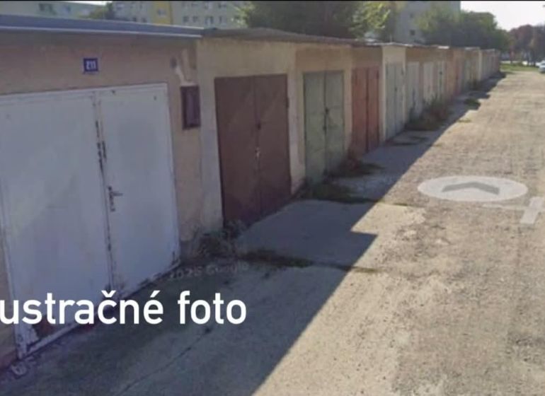 A row of garages in Dunajská Streda with different colored doors on a paved road.