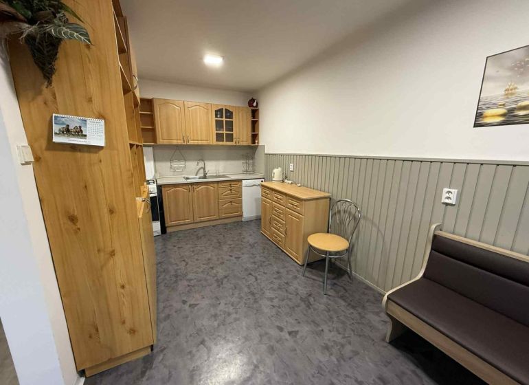 A kitchen in a 4-room apartment with wooden cabinets and a floor with a wooden decor.