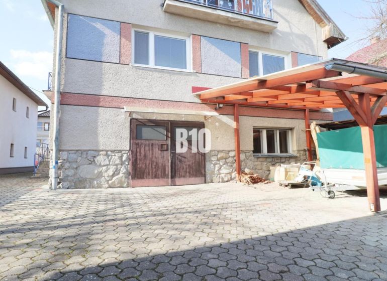 A family house in Turany with a paved driveway and a carport.