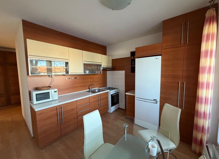 A kitchen in a 3-room apartment with a wooden decor and modern equipment.