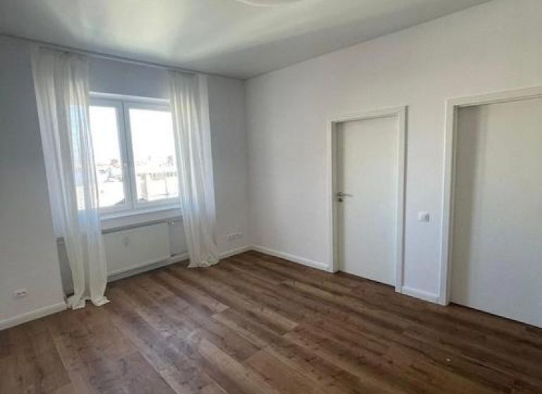 A room with a wooden floor decor, white walls, and curtains in a 3-room apartment.