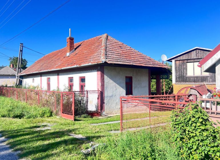 A family house in Žirany, Nitra district, with a red roof and fence.