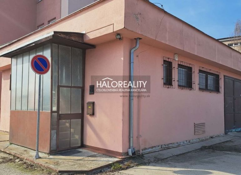 The exterior of an office building in Senec with a no parking sign and metal doors.