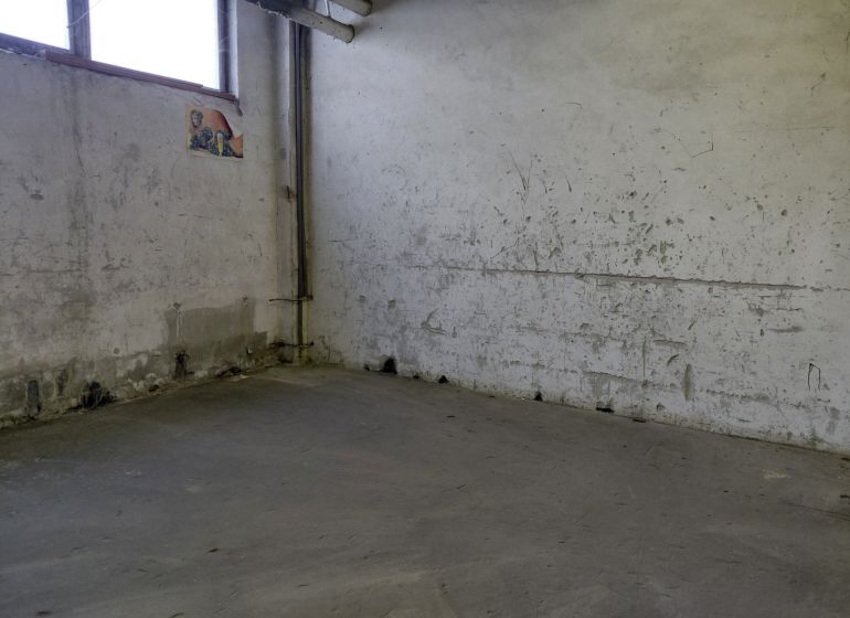 Industrial interior with worn walls and gray flooring, warehouses and halls.
