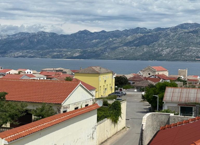 View of the coast and mountains in Ražanac from a family house with red roofs.