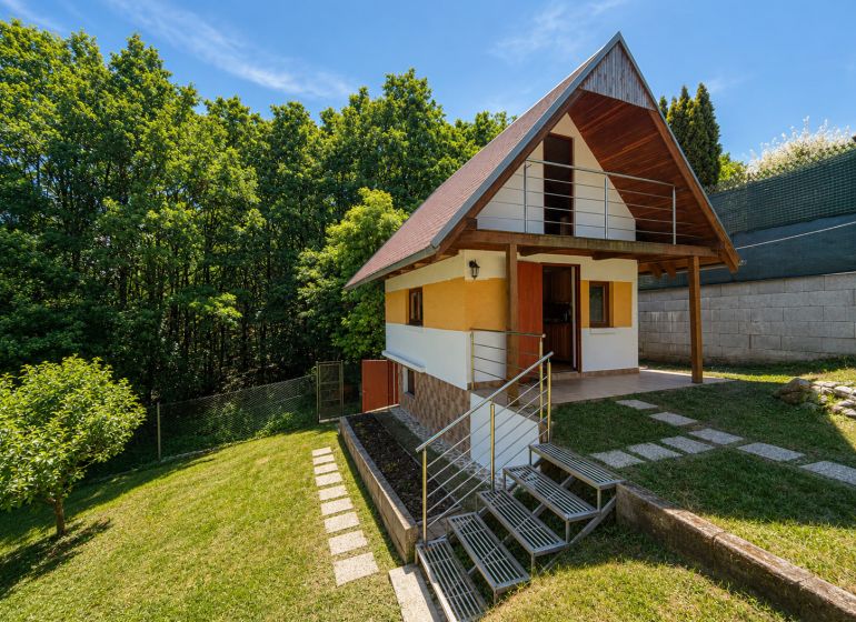 A cottage with wooden decor in Považská Bystrica at Klučina, surrounded by greenery and trees.