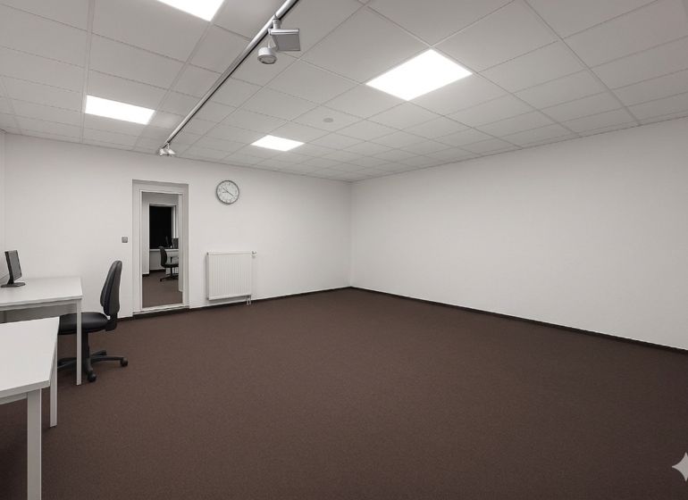 Spacious offices with white walls, brown carpet, and minimalist furnishings.
