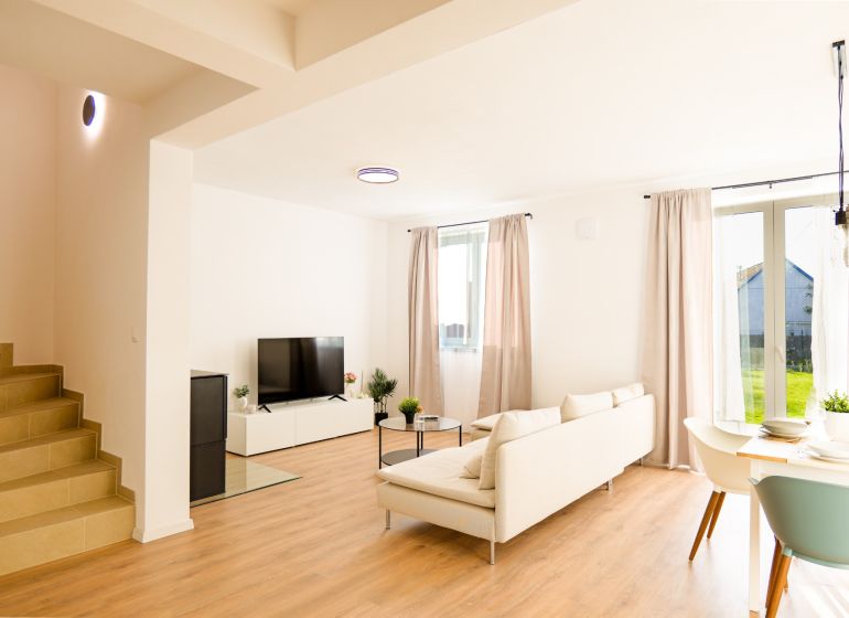 Bright living room of a family house with wood-decor flooring and comfortable seating.