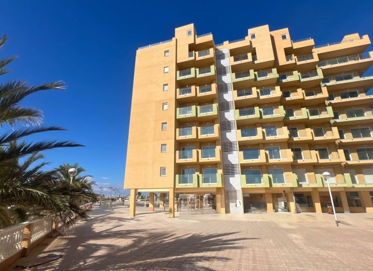 Recreational apartment in La Manga del Mar Menor with palm trees and a clear sky.