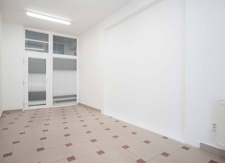Offices with white walls, tiles, and glass doors create a clean space.