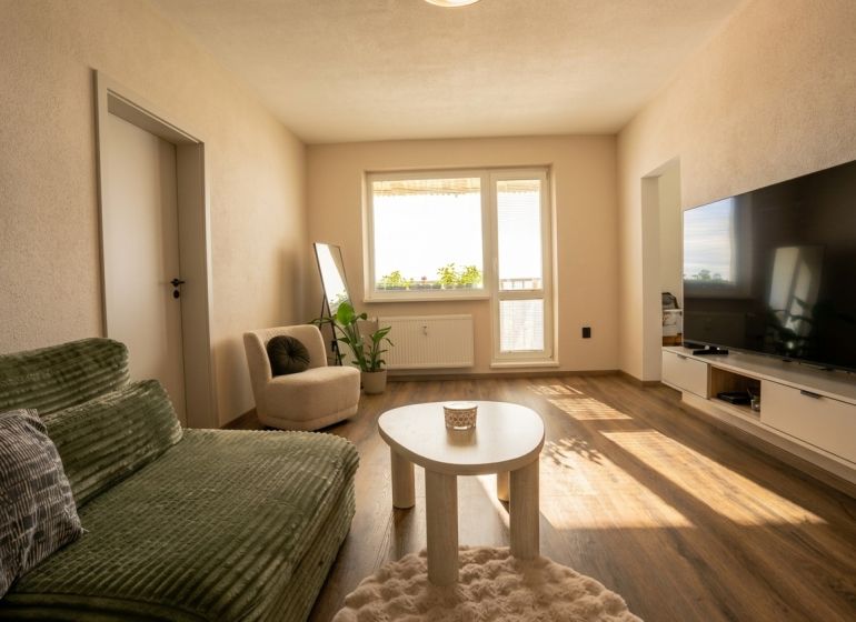Living room in a two-room apartment with a wooden decor floor and comfortable furniture.