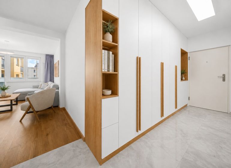 Living room with wood-patterned flooring and a built-in wardrobe in a 3-room apartment.