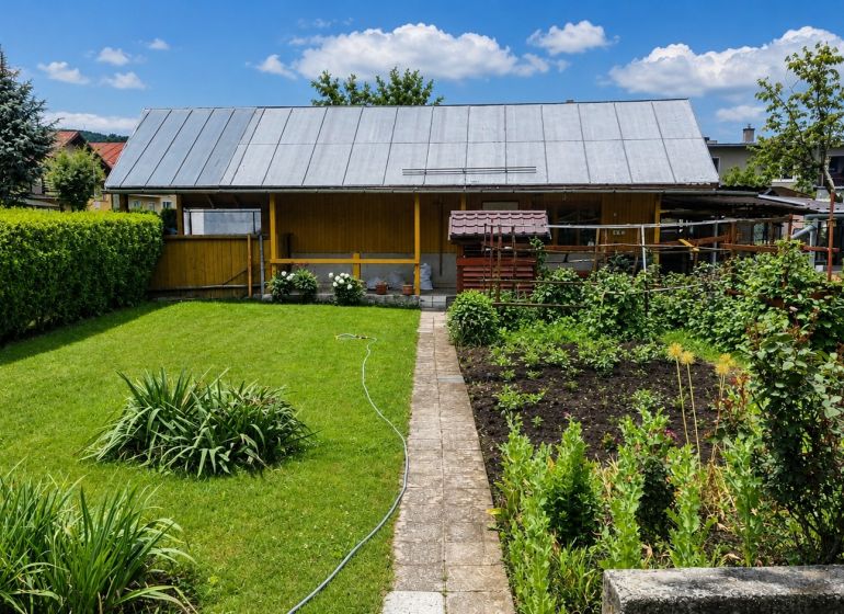 A garden at a family house in Slovenská Ľupča with a manicured lawn and cultivated plants.