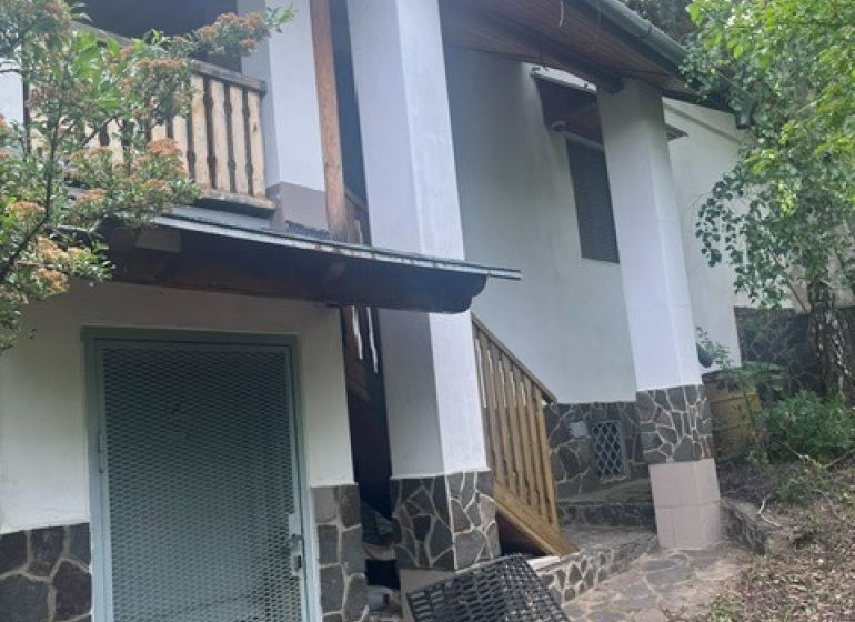 A cottage in Jablonov nad Turňou, surrounded by greenery, with a terrace and stone cladding.